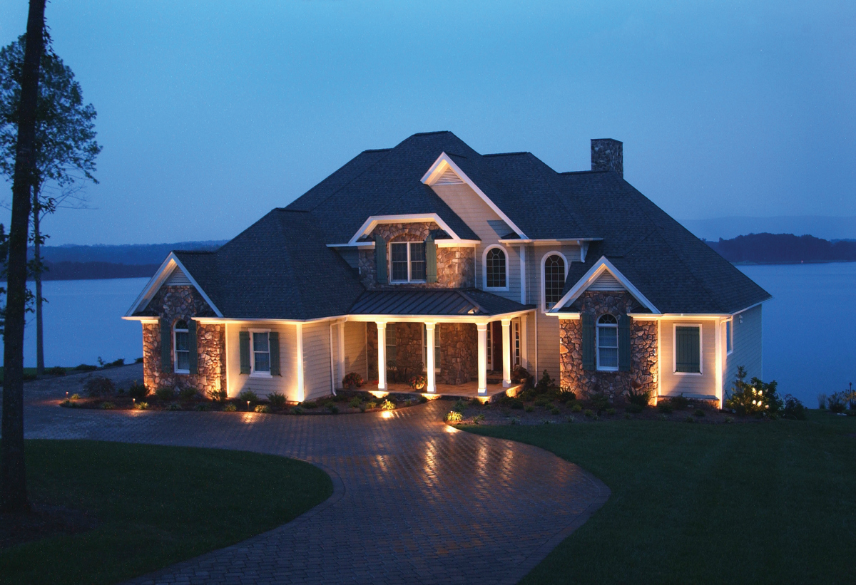 large brick house with exterior house lighting in scarsdale